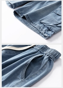 Detail of elastic waist with drawstring and cargo pockets on blue denim shorts