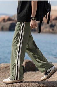 Foto di strada di pantaloni casual verde oliva con nastro a righe laterali