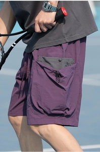 Detail of plum tech fabric shorts featuring a 3D cargo pocket with drawstring and snap button