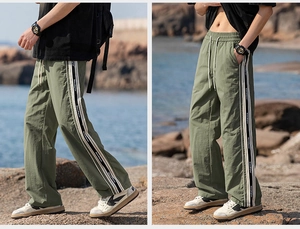 Dettaglio dei pantaloni outdoor verde militare con strisce laterali e coulisse in vita