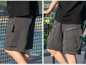 Detail of men's charcoal grey cargo shorts with side flap pockets and drawstring waist