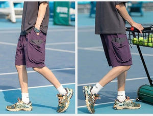 Detail of dark purple quick-dry cargo shorts with utility side pockets and drawstring