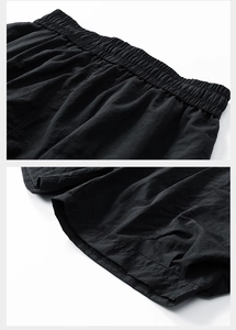 Close-up of black shorts with elastic waistband and lightweight crinkle fabric texture