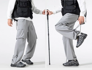 Dettaglio dei pantaloni tecnici grigi con ampie tasche cargo e fondo gamba regolabile