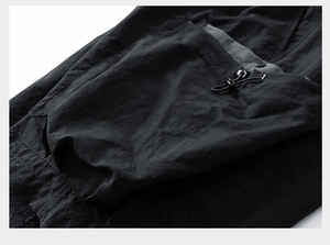 Detail of technical fabric shorts showing adjustable drawstring toggles and texture