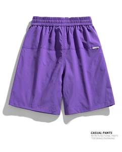 Detail of purple cargo shorts featuring an elastic waistband and minimalist woven label