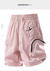 Detail of pink cargo shorts with elastic drawstring waist and black arc zipper pocket
