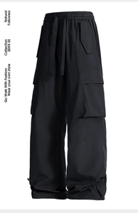 Dettaglio dei polsini regolabili con coulisse e tasche cargo sui pantaloni outdoor neri