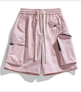 Detail of pink cargo shorts with elastic drawstring waist and functional flap pockets