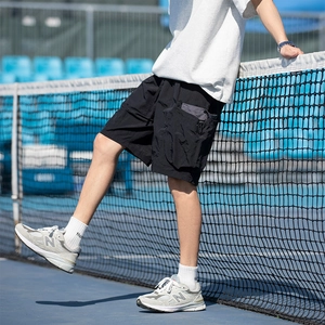 Men's black tactical sports shorts with cargo pockets on a blue tennis court background