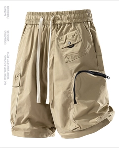 Detail of khaki water-repellent cargo shorts with elastic drawstring waist and tactical pockets