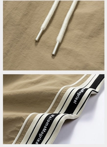 Dettaglio dei pantaloni outdoor kaki con coulisse e nastro con logo sul lato