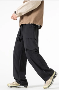 Dettaglio dei pantaloni da trekking neri con orlo regolabile con coulisse e ampie tasche laterali