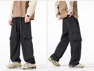 Dettagli dei pantaloni cargo tecnici neri con orlo regolabile e tasche laterali