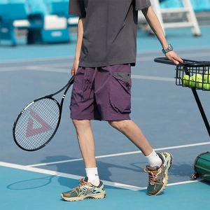 Deep purple cargo shorts with utility pockets shown on an outdoor tennis court