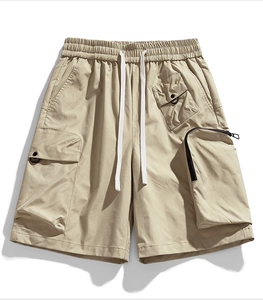 Detail view of khaki cargo shorts with multiple utility pockets and elastic drawstring waist