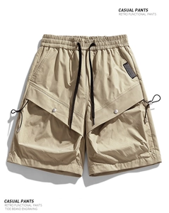 Close-up of khaki cargo shorts showing the elastic waistband and functional multi-pockets