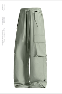 Dettaglio dei pantaloni cargo verde chiaro con vita elastica a coulisse e grandi tasche laterali