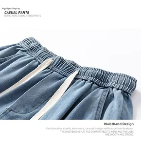 Detail of retro washed blue denim shorts featuring elastic drawstring waistband and stitching