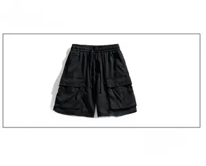 Detail view of water-resistant black cargo shorts with drawstring waist and large flap pockets