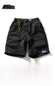 Detail of black utility cargo shorts with quick-release buckle belt and large side pockets