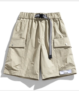 Detail of khaki cargo shorts with adjustable black and white checkered buckle belt
