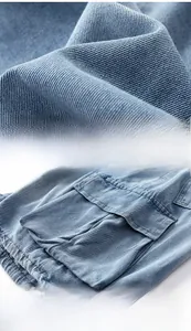 Detailed view of washed blue denim fabric texture and cargo style side pockets