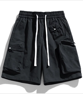 Detail of black tactical cargo shorts featuring water-repellent fabric and multiple utility pockets