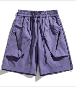 Close-up of purple cargo shorts featuring elastic drawstring waist and black zipper pockets