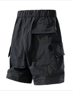 Detail of black water-repellent cargo shorts featuring elastic waist and large side pockets