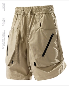 Detailed view of khaki cargo shorts featuring elastic drawstring waist and tactical zip pockets