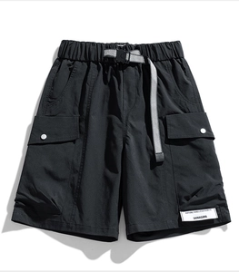 Detail of black cargo shorts featuring water-repellent fabric and checkerboard belt