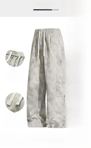 Detailed views of gray tie-dye cargo pants with elastic waist and drawstring features