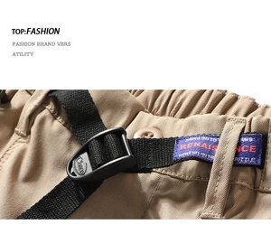 Detail of khaki cargo shorts showing the elastic waistband and Chaco nylon belt buckle