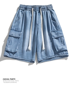 Detail view of large cargo pockets and adjustable drawstring on washed denim shorts