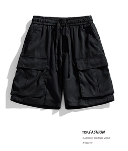 Detailed macro view of black waterproof cargo shorts with elastic drawstring waist and flap pockets