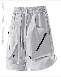 Detail view of light grey cargo shorts featuring adjustable drawstring waist and zip pockets
