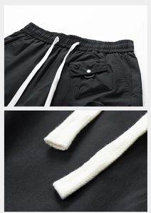 Detail of water-repellent cargo shorts with elastic drawstring waist and tactical side pockets