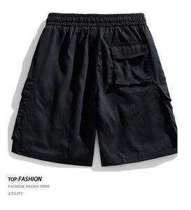 Detailed view of elastic waistband and functional cargo pockets on black summer shorts