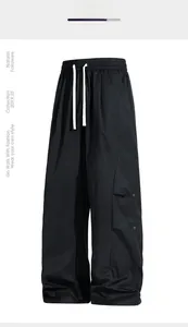 Detail showing elastic waistband with contrast drawstrings and cargo pockets on black trousers