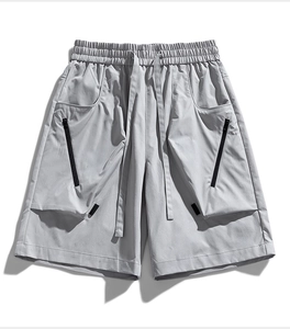 Detailed view of men's cargo shorts featuring large 3D pockets and black diagonal zippers