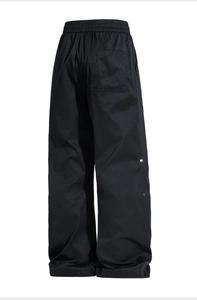 Detail view of black high waist wide leg pants with elastic waist and metal eyelet accents
