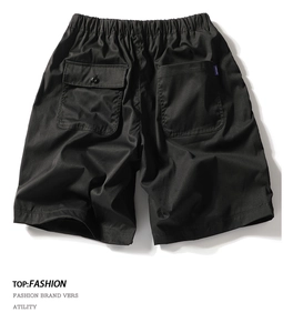 Detailed view of black cargo shorts featuring rear buttoned pockets and City Boy woven label