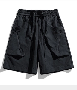Detail of black tactical cargo shorts with large zipper pockets and elastic drawstring waist
