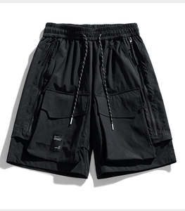 Dettaglio dei pantaloncini cargo neri con vita elastica, coulisse e ampie tasche laterali