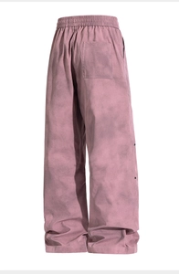 Detail view of pink tie-dye trousers with elastic waist and side snap buttons