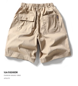 Detail of khaki cargo shorts showing elastic waist and large back pockets with blue woven label