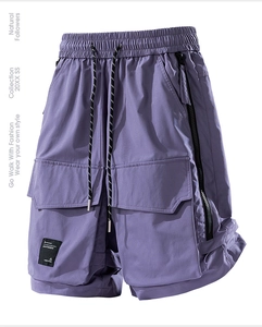 Dettaglio di pantaloncini cargo viola con elastico in vita, coulisse e cerniera laterale