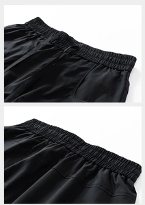 Detail of black athletic shorts featuring an elastic drawstring waistband and high-density stitching