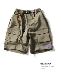 Detail of army green cargo shorts with elastic waistband and black nylon buckle belt
